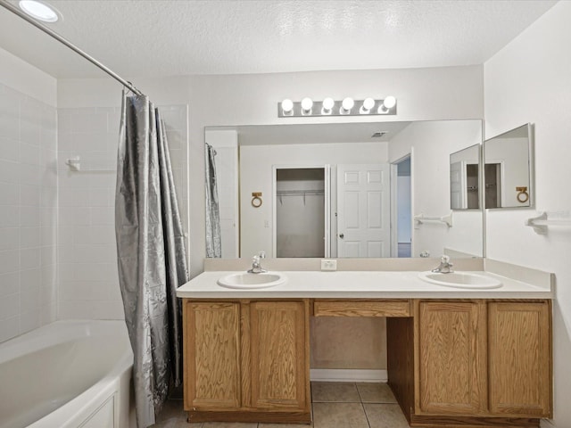 bathroom with vanity, a textured ceiling, shower / bathtub combination with curtain, and tile patterned floors