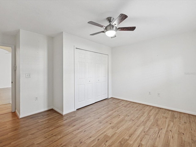 unfurnished bedroom with a closet, light hardwood / wood-style floors, and ceiling fan