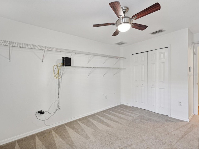 laundry area featuring ceiling fan and carpet floors