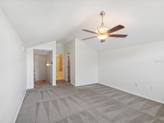 spare room featuring lofted ceiling, light carpet, and ceiling fan