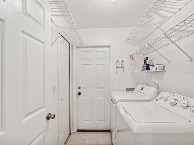 laundry room with light tile patterned flooring and washer and dryer