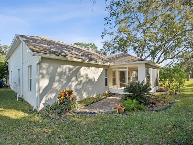 back of house with central air condition unit and a lawn