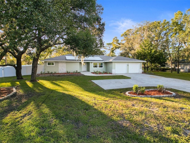 ranch-style home featuring solar panels, a garage, and a front lawn