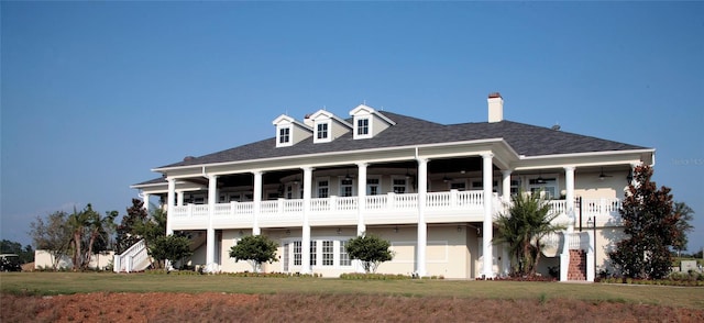 back of property with a yard and a balcony