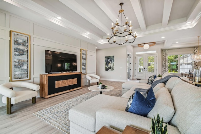 living room featuring a chandelier, ornamental molding, beamed ceiling, light hardwood / wood-style floors, and french doors