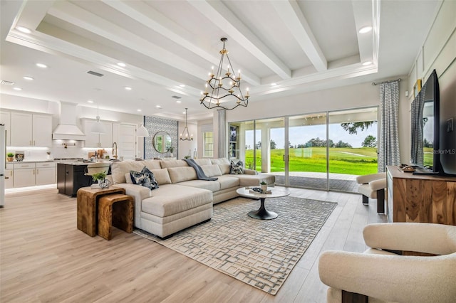 living room featuring light hardwood / wood-style floors, beam ceiling, and a chandelier