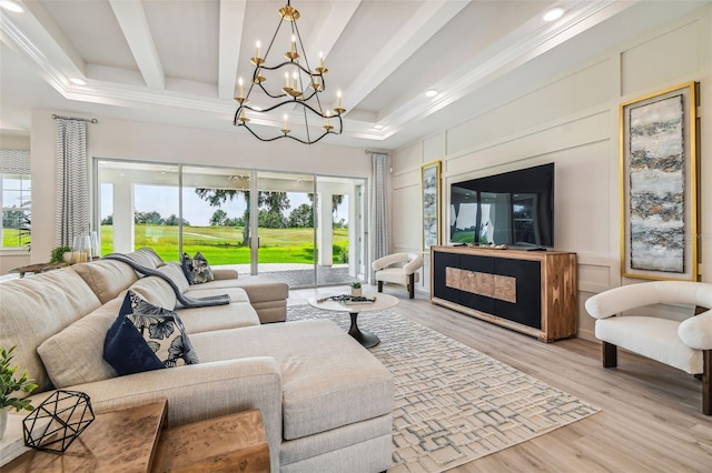 living room featuring an inviting chandelier, light hardwood / wood-style flooring, beam ceiling, and a wealth of natural light