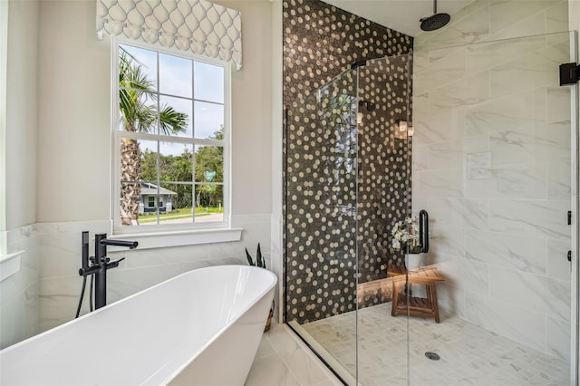 bathroom featuring independent shower and bath, plenty of natural light, and tile walls