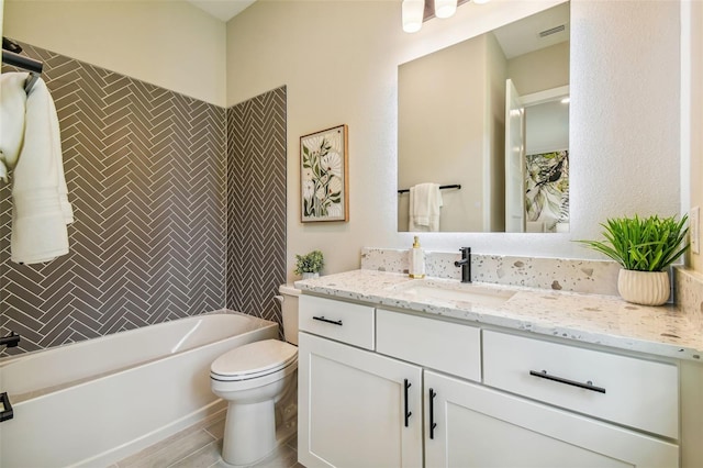 full bathroom with vanity, tiled shower / bath, and toilet