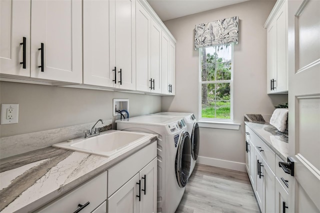 laundry area with light hardwood / wood-style floors, cabinets, plenty of natural light, and independent washer and dryer