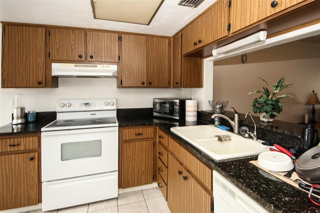 kitchen with white appliances, light tile patterned floors, and sink