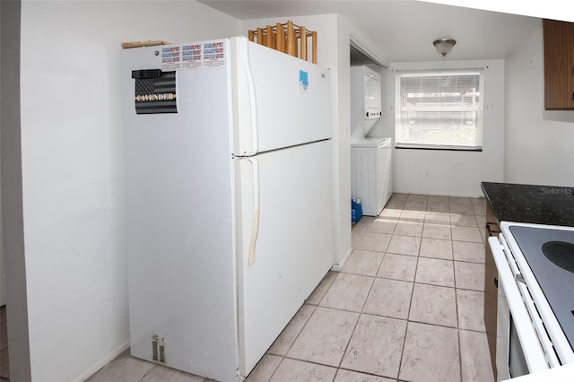 kitchen featuring white appliances, stacked washing maching and dryer, and light tile patterned floors