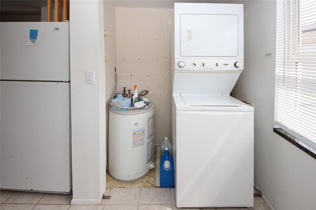 laundry area with stacked washer / drying machine, light tile patterned floors, and water heater