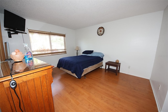 bedroom with a textured ceiling and hardwood / wood-style flooring