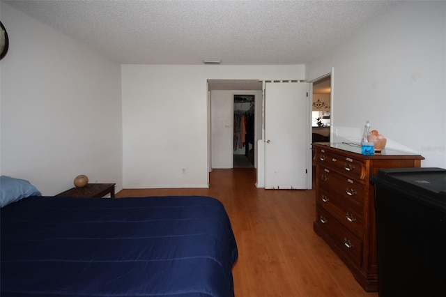 bedroom featuring a closet, a textured ceiling, and wood-type flooring