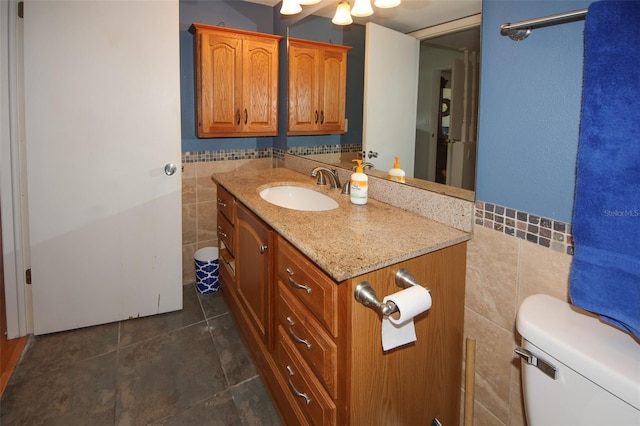 bathroom featuring vanity, tile walls, toilet, and tile patterned floors