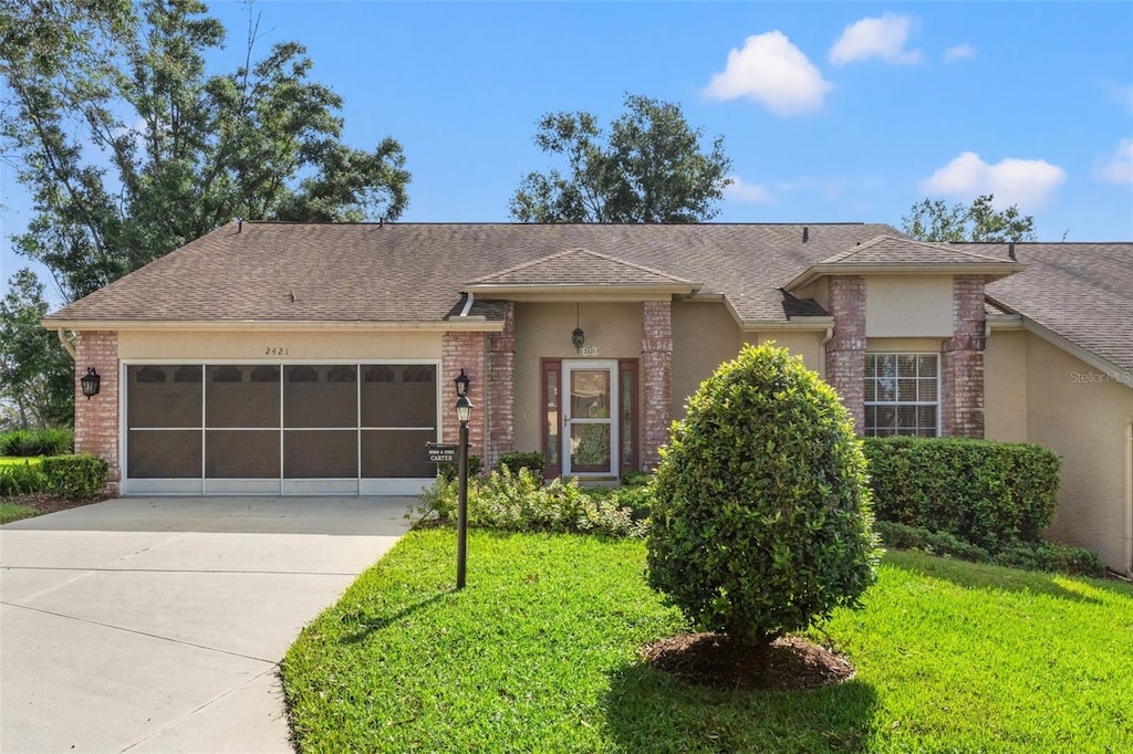 ranch-style home with a front lawn and a garage