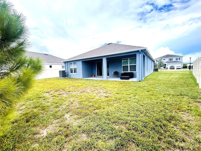 rear view of property with a patio area, central AC, and a lawn