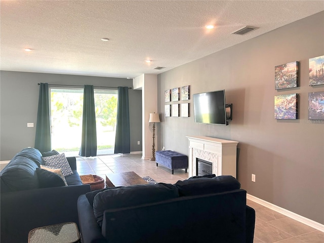 tiled living room featuring a textured ceiling