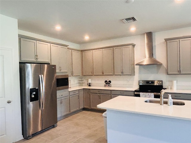 kitchen with appliances with stainless steel finishes, sink, wall chimney range hood, and light tile patterned floors