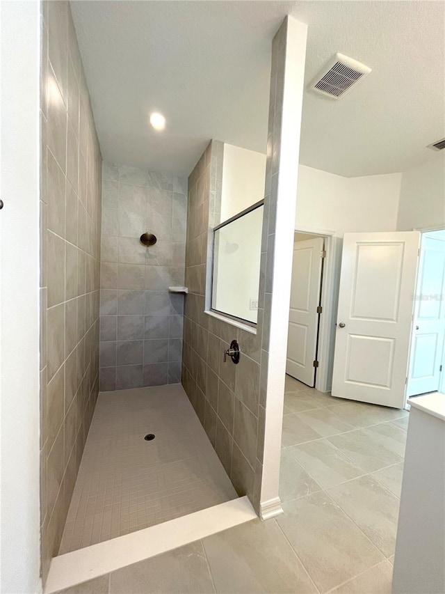 full bath with tile patterned flooring, a tile shower, and recessed lighting