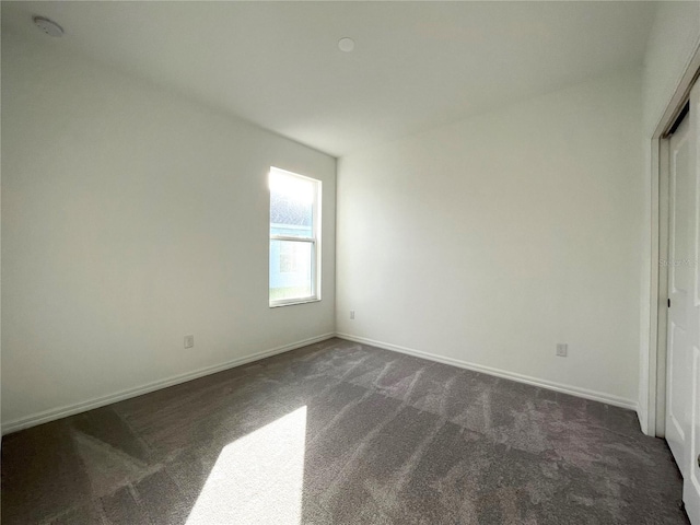 unfurnished bedroom with dark colored carpet