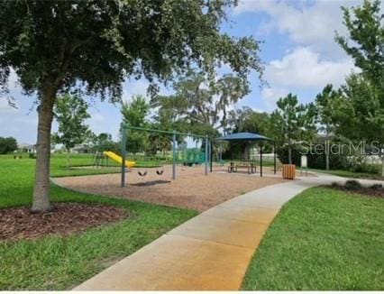 view of home's community with a lawn and a playground