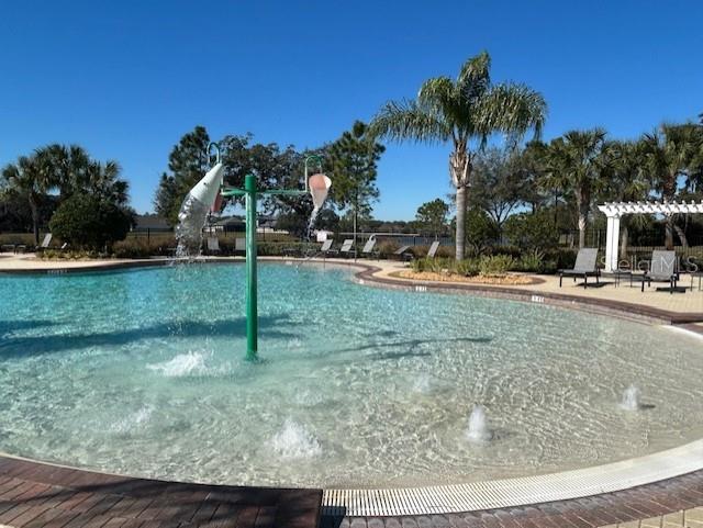 view of swimming pool featuring a pergola, a patio area, and a water slide