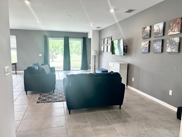 13447 Newport Shores Dr, Hudson, FL 34669 - living area featuring light tile patterned floors
