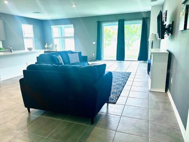 13447 Newport Shores Dr, Hudson, FL 34669 - living area featuring light tile patterned floors and baseboards