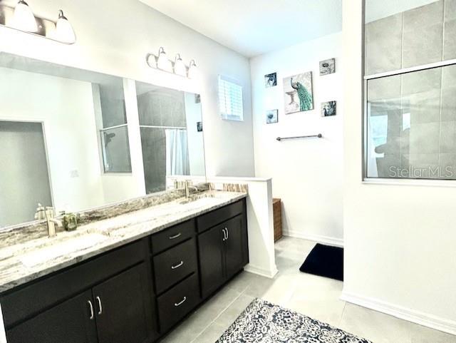 13447 Newport Shores Dr, Hudson, FL 34669 - full bath featuring tiled shower, double vanity, and tile patterned floors