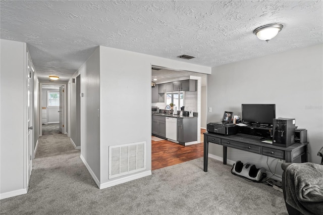 carpeted office space with a textured ceiling