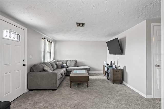 carpeted living room featuring a textured ceiling