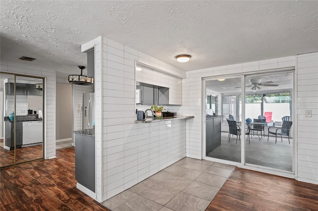 kitchen with hardwood / wood-style floors, stainless steel fridge with ice dispenser, a textured ceiling, and white dishwasher