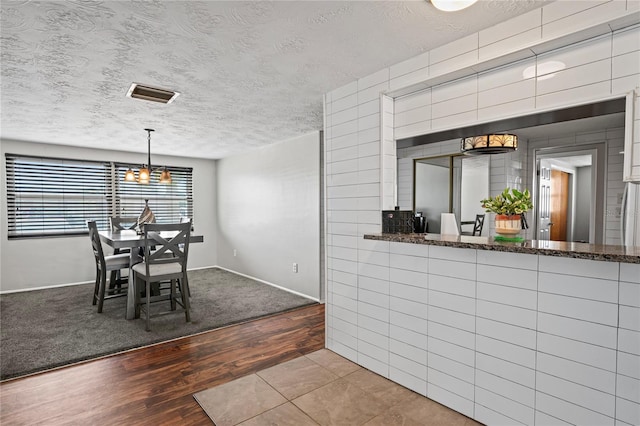 dining space featuring a textured ceiling and light hardwood / wood-style floors