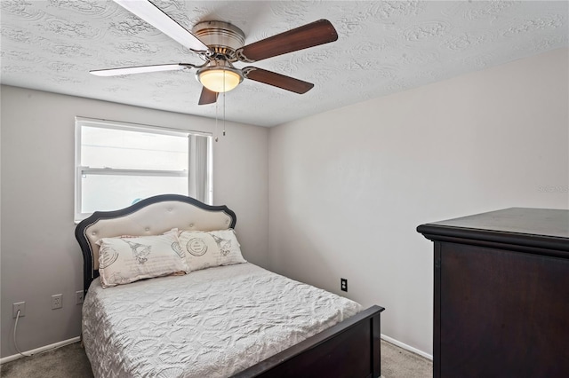 carpeted bedroom with ceiling fan and a textured ceiling