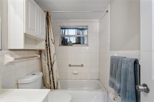 full bathroom featuring vanity, shower / bathtub combination with curtain, toilet, and tile walls