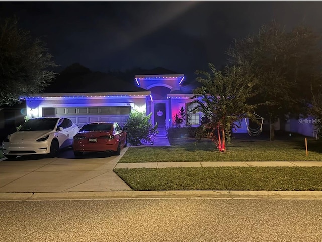 view of front of property featuring a garage and a lawn