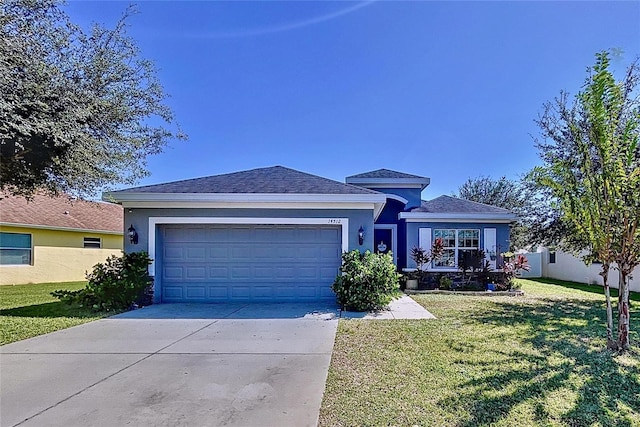 view of front of property with a front yard and a garage