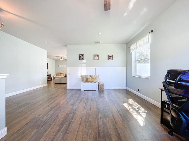 living area featuring dark wood-type flooring and ceiling fan