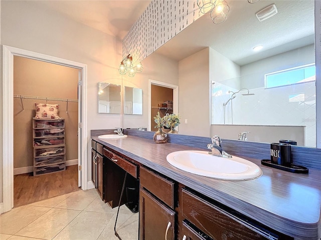 bathroom featuring vanity, a shower, and tile patterned flooring