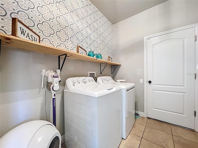 clothes washing area featuring light tile patterned floors and washing machine and clothes dryer