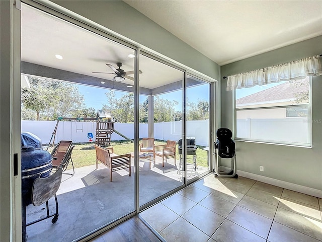 doorway with light tile patterned floors and ceiling fan