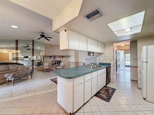 kitchen with kitchen peninsula, white cabinetry, white fridge, and sink