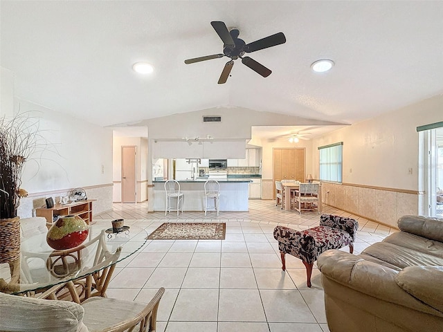 living room with vaulted ceiling, ceiling fan, and light tile patterned flooring