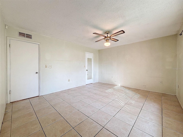 tiled spare room with ceiling fan and a textured ceiling