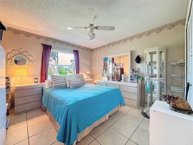 tiled bedroom with ceiling fan and a textured ceiling