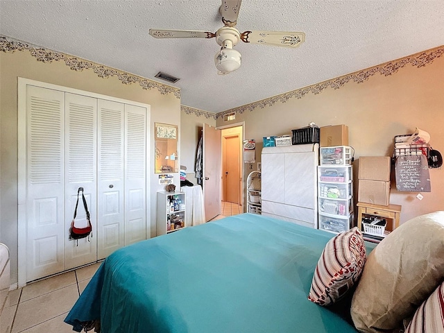 tiled bedroom featuring a textured ceiling, a closet, and ceiling fan