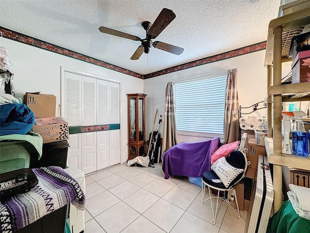 bedroom with a closet, ceiling fan, and a textured ceiling