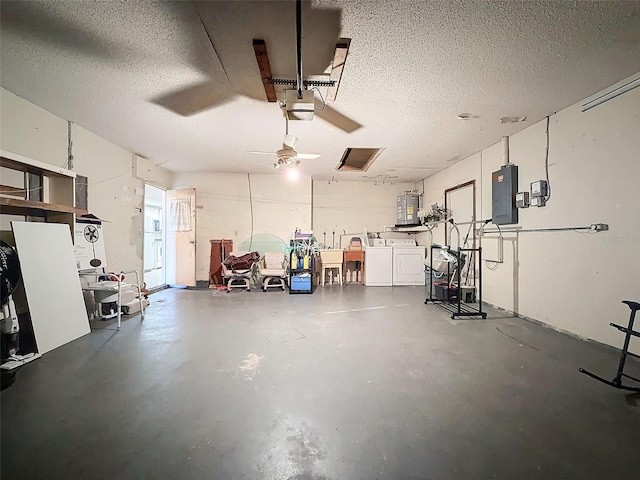 garage with sink, independent washer and dryer, a garage door opener, electric water heater, and electric panel